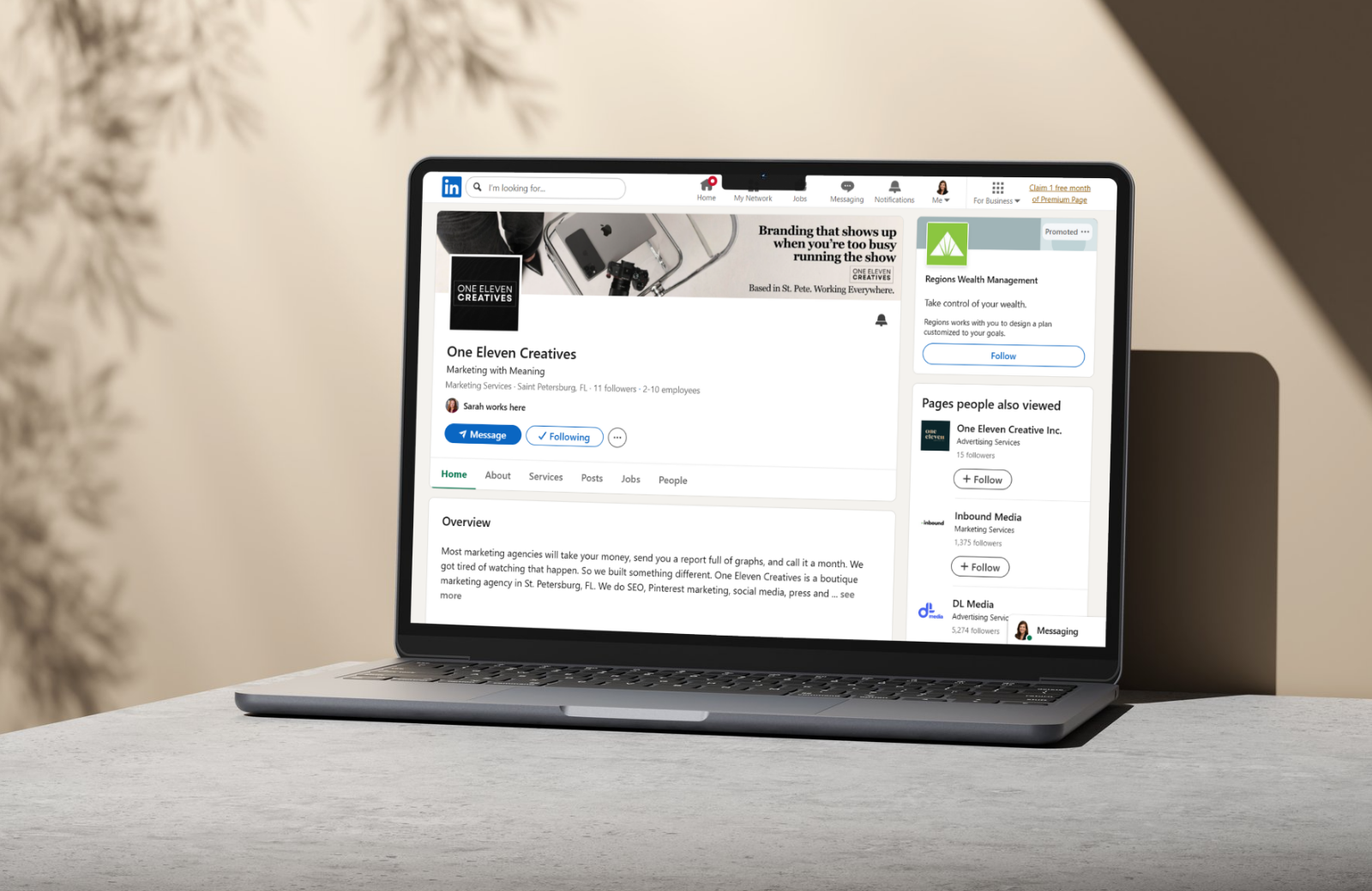 Laptop on desk open to LinkedIn One Eleven Creatives