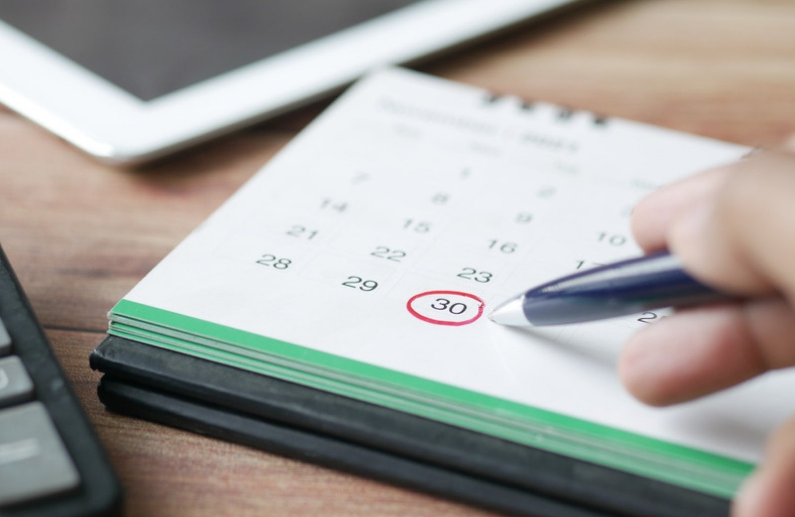 Hand circling a date on a calendar, representing a PR timeline