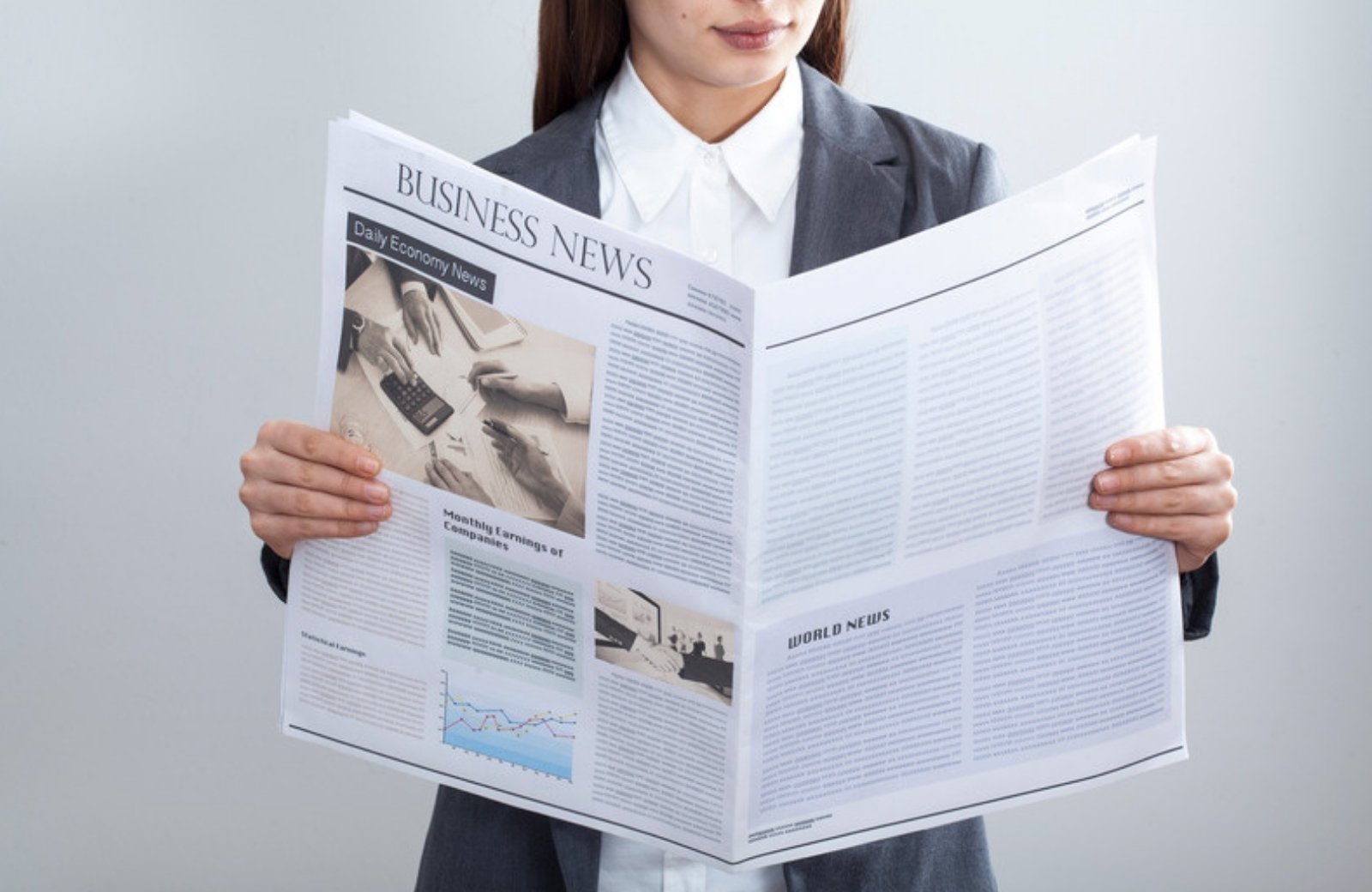 Businesswoman reading the business news section of a newspaper