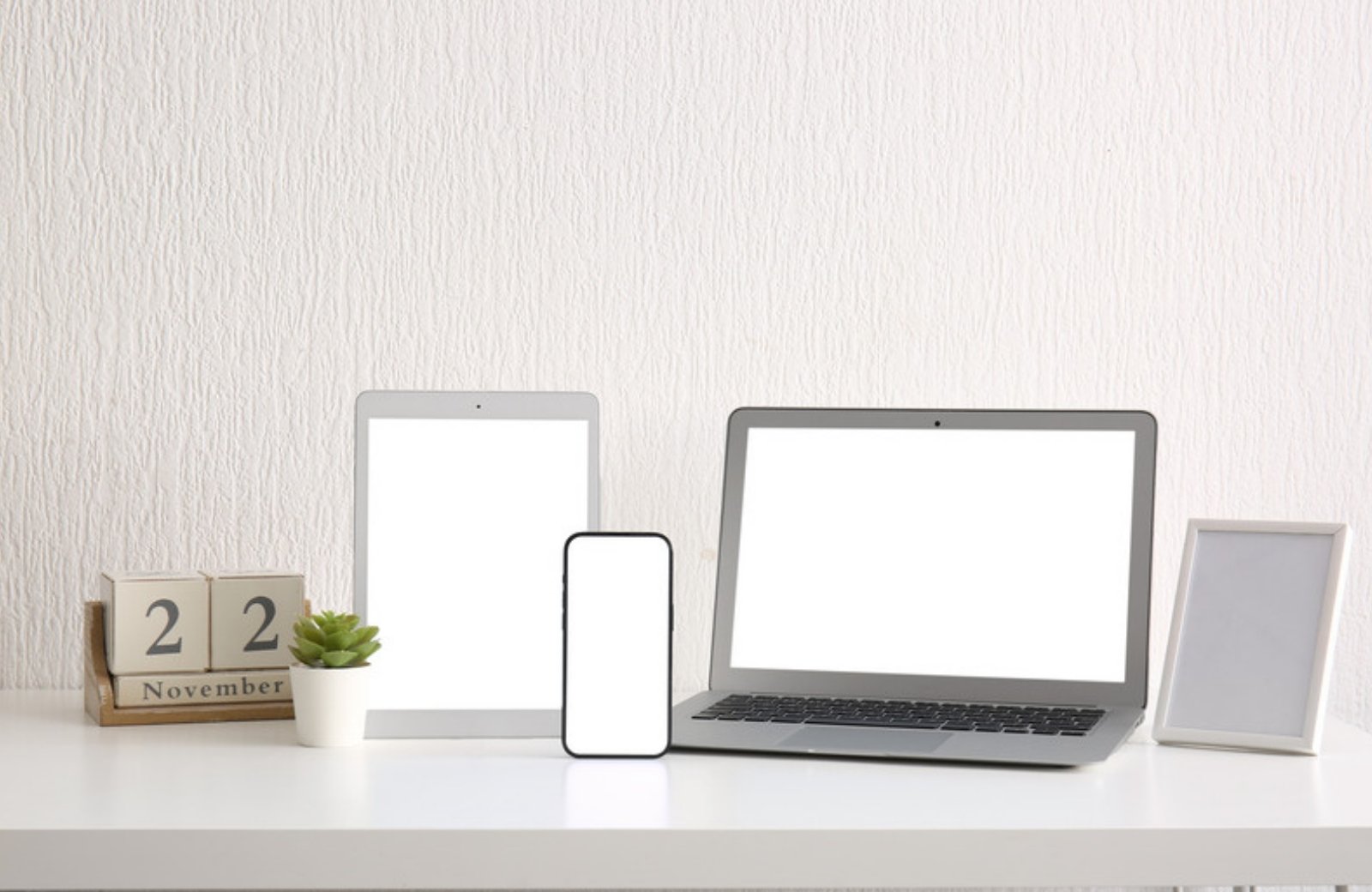 Laptop, tablet and phone on a desk, representing website speed across devices
